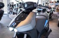 Grauer E-Scooter im Frontal- und Seitenprofil im Autohaus.