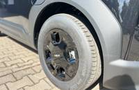 Detailaufnahme des schwarzen Rades und Reifens eines KIA EV2.