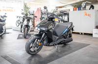 Außenansicht eines dunklen elektrischen Scooters in einem Showroom.