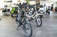 Mehrere schwarze E-Lastenräder stehen in einem hellen Showroom.