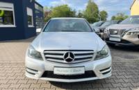 Frontalansicht des silbernen Mercedes-Benz C180 auf dem Parkplatz des Autohauses.