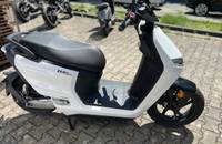 Ein weißer elektrischer Roller (ZERO LS1) auf Pflastersteinen im Autohaus.
