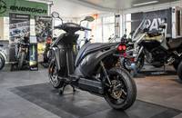 Seitenansicht eines schwarzen elektrischen Rollers in einem Showroom.