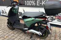 Grüner und schwarzer Piaggio E-Scooter in einer Dreiviertel-Ansicht.