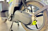 Nahaufnahme des Hinterrads eines E-Scooters, die die Federung, das Rad und den Motorbereich zeigt.