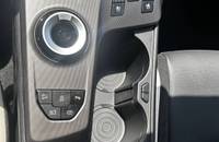 Mittelkonsole des Autos mit Schalthebel, Bedienelementen und Getränkeablage.