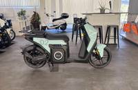 Seitenansicht eines mintgrünen elektrischen Scooters (SILENCE S02) in einem Showroom.