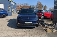 Dunkelblauer Nissan Micra EV vor dem Autohaus Richter & Zech.