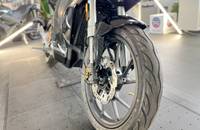 Nahaufnahme des Hinterrads und der Bremsscheibe eines schwarzen Motorrads.
