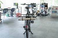 Ein schwarzes Lasten-E-Bike steht in einem hellen Showroom.