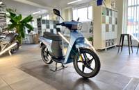 Blauer elektrischer Roller (Andre NGS2) in einem Autohaus-Showroom.