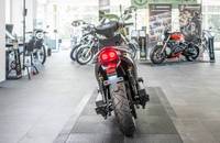 Heckansicht eines schwarzen Motorrads in einem hellen Showroom.