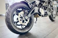 Detailaufnahme des vorderen Reifens, der Bremsscheibe und des Unterbaus eines elektrischen Motorrads.