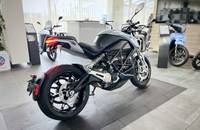 Silbernes Motorrad in Dreiviertelansicht in einem Autohaus.