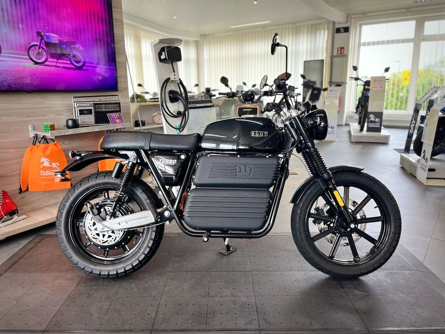 Seitenansicht eines schwarzen RGNT TURBO Motorrads in einem Showroom.