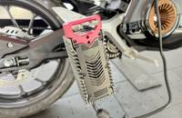 Nahaufnahme des Ladeanschlusses und des Rades eines elektrischen Motorrads.