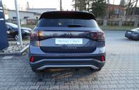 Heckansicht eines VW T-Cross in Rauchgrau Metallic, geparkt auf einem Pflasterboden.