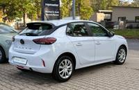 Außenansicht eines weißen Opel Corsa auf einem Autohausparkplatz.