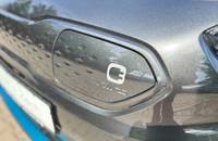 Detailaufnahme des Heckbereichs eines grauen KIA E-Niro mit Herstellerlogo.