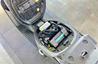 Nahaufnahme des geöffneten Fachs, das die internen Komponenten, Kabel und Struktur des Elektrofahrzeugs zeigt.