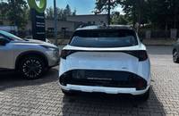Heckansicht eines weißen KIA Sportage, geparkt auf einem Autohaus-Gelände.