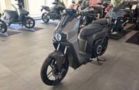 Grauer elektrischer Scooter in Dreiviertelansicht in einem Showroom.
