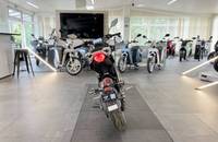 Ansicht mehrerer E-Scooter in einem hellen Autohaus-Showroom.