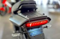 Nahaufnahme des Heckleuchtenbereichs eines E-Motorrads. Die roten LED-Lichter sind sichtbar.