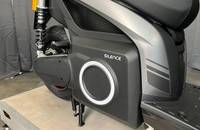 Seitenansicht des grauen elektrischen Scooters mit Akkugehäuse und Federung.