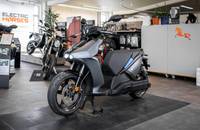 Seitenansicht des grauen E-Motorrads RAY 7.7, das in einem Showroom steht.