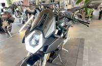 Frontansicht eines schwarzen Motorrads in einem Showroom.