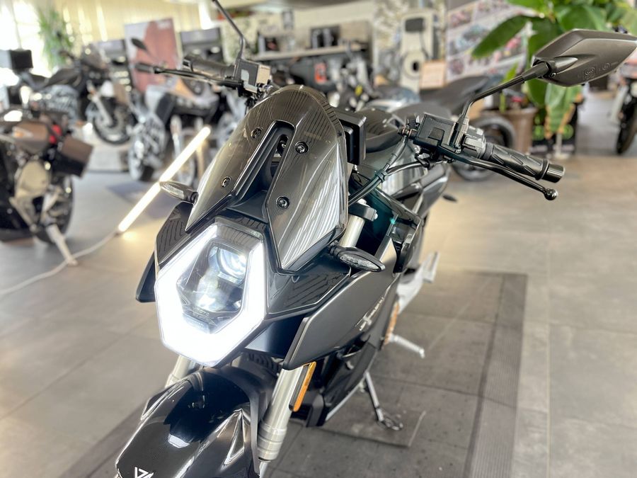 Frontansicht eines schwarzen Motorrads in einem Showroom.