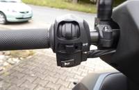 Nahaufnahme der Bedienelemente am Lenker eines Motorrollers.