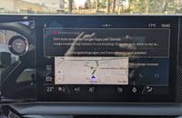 Digitales Infotainment-Display mit Navigationskarte und Fahrzeugsteuerungen.
