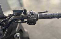Nahaufnahme des Lenkers und der Bedienelemente eines elektrischen Motorrollers.