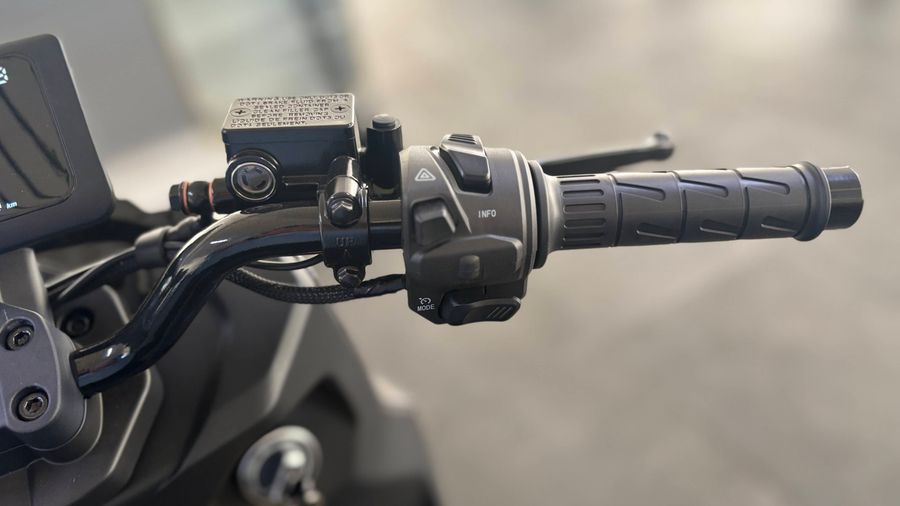 Nahaufnahme des Lenkers und der Bedienelemente eines elektrischen Motorrollers.