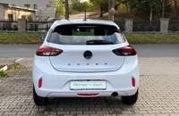 Heckansicht des weißen Opel Corsa auf dem Parkplatz des Autohauses.