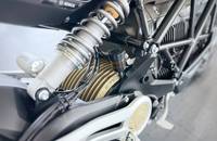 Nahaufnahme der Federung und des Rahmens eines E-Motorrads mit sichtbaren Komponenten.