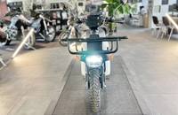 Frontansicht eines weißen Elektro-Motorrollers mit Scheinwerfer und Gitterrost.