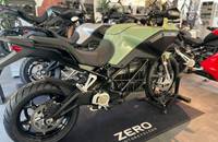 Sagegrünes E-Motorrad in Dreiviertelansicht, präsentiert in einem Showroom.