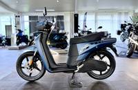 Seitenansicht eines blauen ANDERE NGS3 Elektrorollers, der in einem Showroom steht.