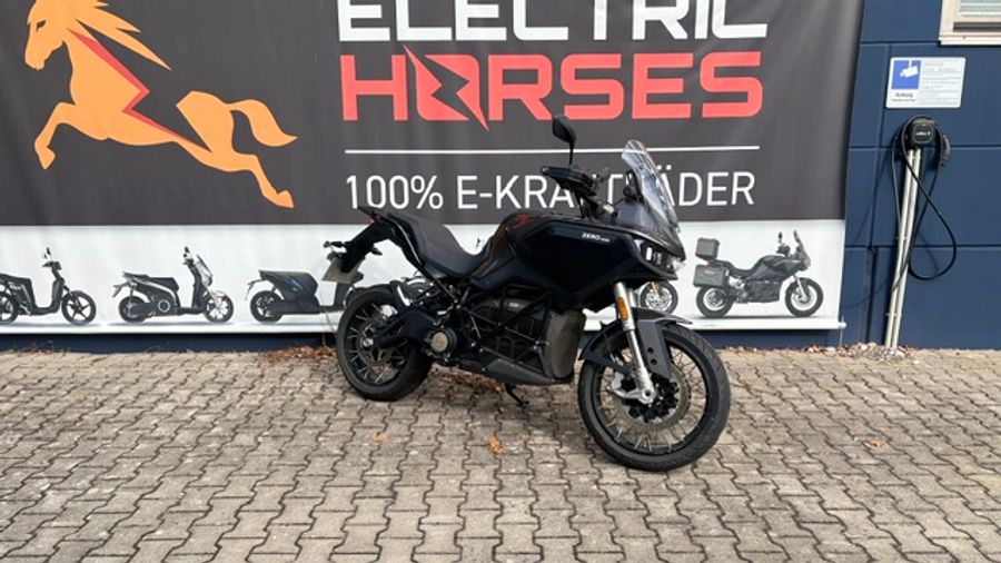 Schwarzes Adventure-Motorrad vor dem Autohaus Electric Horses.