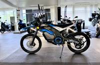 Seitenansicht eines blauen E-Motorrads (VMOTO ON-R) in einem Autohaus.