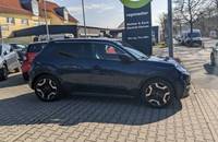 Dunkelblauer Nissan Micra EV in Seitenansicht vor dem Autohaus.