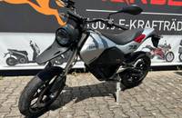 Silbernes E-Motorrad der Marke ZERO, aufgenommen im Freien auf Kopfsteinpflaster.