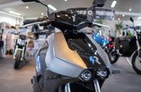 Nahaufnahme der Front eines grauen E-Motorrads mit Lenker und Scheinwerfer.