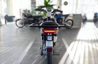 Heckansicht eines weißen Elektro-Scooters in einem Showroom. Die Rückleuchten und das Heck sind zu sehen.