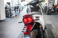 Heckansicht eines weißen E-Scooters mit roten Rückleuchten.