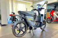 Seitenansicht eines dunklen E-Scooters (ANDERE eS3 EVO) in einem Showroom.