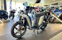 Seitenansicht eines modernen, grauen Elektro-Scooters in einem Autohaus.